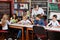 Teacher Showing Book To Schoolboy In Library