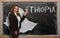 Teacher showing map of ethiopia on blackboard