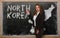 Teacher showing map of north korea on blackboard