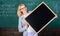 Teacher smart smiling woman hold blackboard blank advertisement copy space. School schedule and information. Hometask