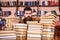 Teacher or student with beard sits at table with books, defocused. Man on serious face between piles of books, while