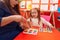 Teacher and student playing with maths puzzle game looking cards at kindergarten