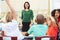 Teacher Talking To Elementary Pupils In Classroom