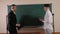 A teacher talks near the blackboard with a student in the mathematics class.