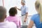 A teacher talks to school children in a class