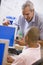 A teacher talks to a schoolboy using a computer