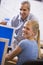 A teacher talks to a schoolgirl using a computer