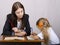 The teacher teaches lessons with a student sitting at the table