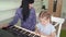 Teacher teaches little girl to play on synthesizer