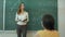Teacher teaching mathematics on chalkboard in classroom