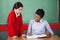 Teacher Teaching Schoolgirl At Desk