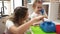 Teacher and toddler playing with telephone toy at kindergarten