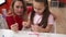 Teacher and toddler sitting on table playing at kindergarten