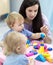 Teacher and toddlers playing with color blocks