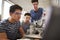 Teacher With Two Male College Students Building Machine In Science Robotics Or Engineering Class