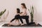 The teacher of universal yoga performs the straightening of the spine of a student sitting on a mat in the lotus position