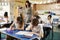 Teacher walking in her busy primary school classroom