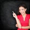 Teacher woman holding chalk by blackboard