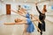 Teacher works with ballerinas at barre in class