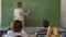 Teacher writing on blackboard in class