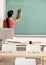 Teacher writing on chalk board in classroom