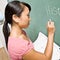 Teacher writing on chalk board in classroom