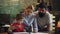 Teachers and pupil in class. Cute little boy studying with father and mother.