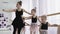 Teachers show how to dance to little ballerinas. Girl dancer in ballet school learns to dance. Young ballerinas jumping