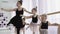 Teachers show how to dance to little ballerinas. Girl dancer in ballet school learns to dance. Young ballerinas jumping