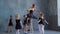 Teachers show how to dance to little ballerinas. Girl dancer in ballet school learns to dance. Young ballerinas jumping