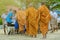 Teachers and students together make merit to give food offerings to a Buddhist monk on important religious days