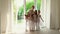 Teachers together with smoy schoolgirls are by the window of a ballet school. Ballerinas in white studio of the ballet