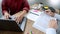 Teaching helping technology concept. Woman young teacher or tutor with adult students in classroom at desk with papers, laptop