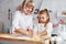 Teaching process. Senior grandmother with her little granddaughter cooks sweets for Christmas on the kitchen