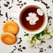 Teacup with dried and fresh Jasmine flowers and cookie