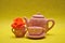 A teacup and a kettle with an orange rose