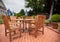 Teak patio tables and chairs on brick deck