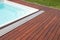 Teak wood pool deck, high quality hardwood decking installed around the blue swimming pool