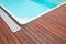 Teak wood pool deck, high quality hardwood decking installed around the blue swimming pool