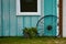 Teal barn with wagon wheel window and flower kettle planter