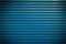 Teal blue painted horizontal metal window roller shutter blinds or garage doors background texture