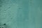 Teal color rough textured painted wall background