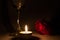 Tealight candle, wine glass and rose