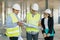 Team of builders engineers at construction site, reading blueprint. Construction, development, teamwork and people concept