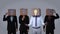 Team of businessman hiding head with box and gesturing