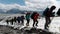 A team of climbers ascending an icy slope on Mt. Everest across the sky above. Clip. People enjoying climbing a snowy