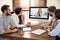 Team of coworkers having video chat with boss in office