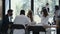 Team of diverse young happy business people working at modern office table wearing masks. Safety measures at workplace.