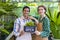 Team of diversity garden worker holding opening sign to welcome customer to their tropical nursery plant center full of exotic