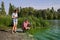 Team of ecologists take samples of green algae on bank of polluted river